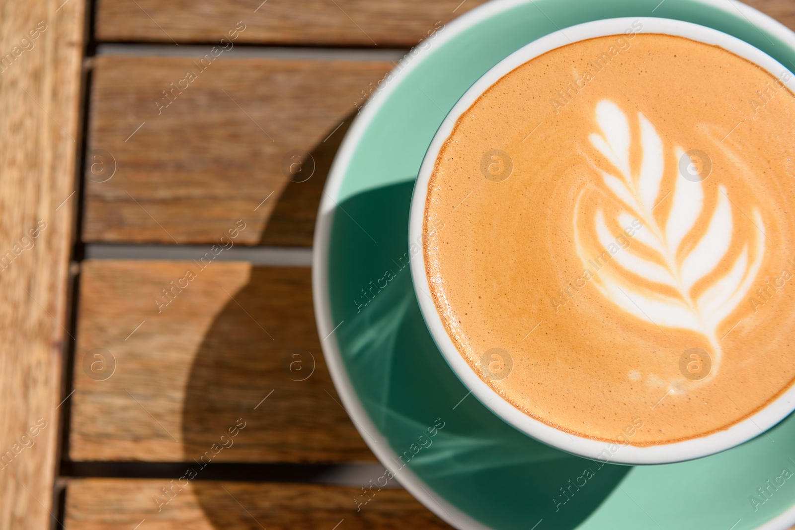 Photo of Cup of aromatic hot coffee on wooden table, top view. Space for text