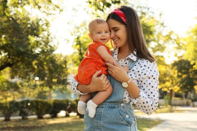 Photo of Young mother with her cute baby in park on sunny day