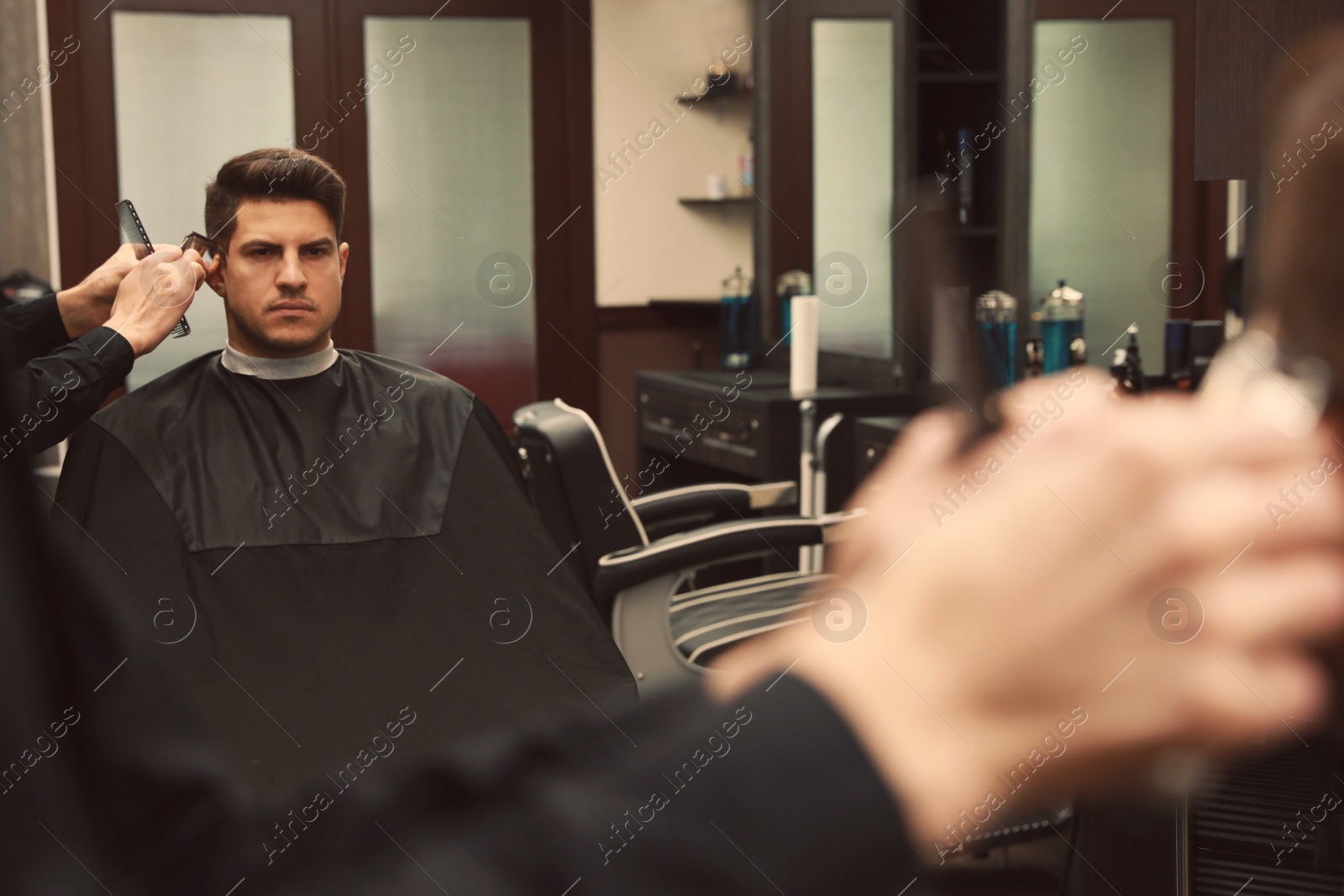 Photo of Professional hairdresser making stylish haircut in salon