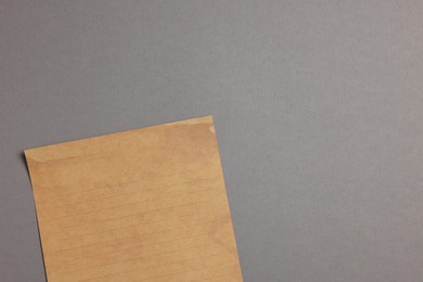 Photo of Sheet of old parchment paper on grey background, top view. Space for text