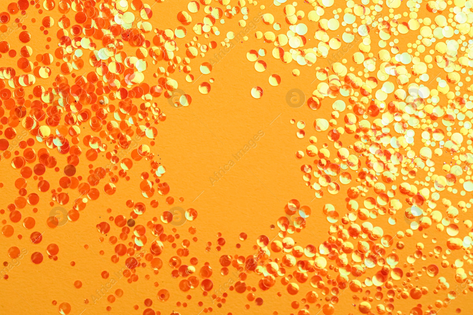 Photo of Shiny bright glitter on yellow background, flat lay