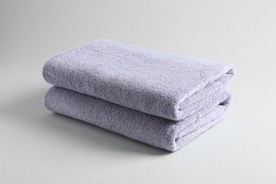 Stack of fresh fluffy towels on grey background