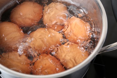 Chicken eggs boiling in pot, closeup view