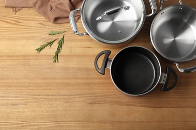 Photo of Flat lay composition with clean cookware and space for text on wooden background