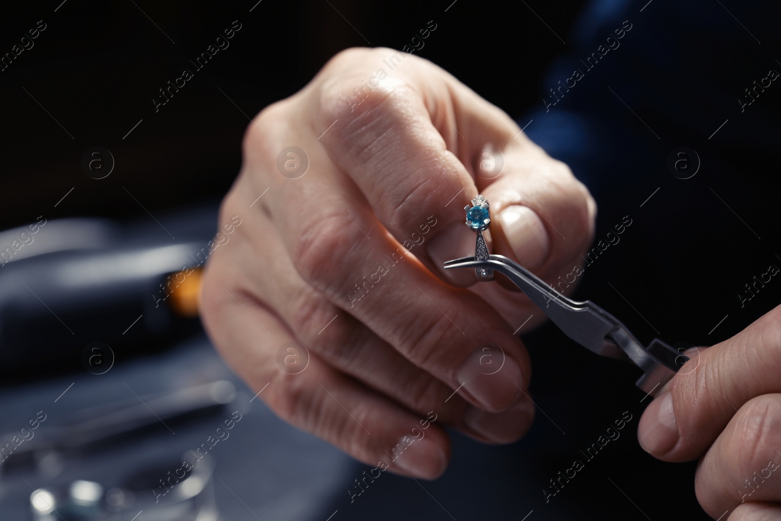 Photo of Professional jeweler working with ring, closeup view