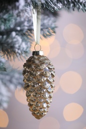 Christmas tree decorated with holiday bauble against blurred lights, closeup