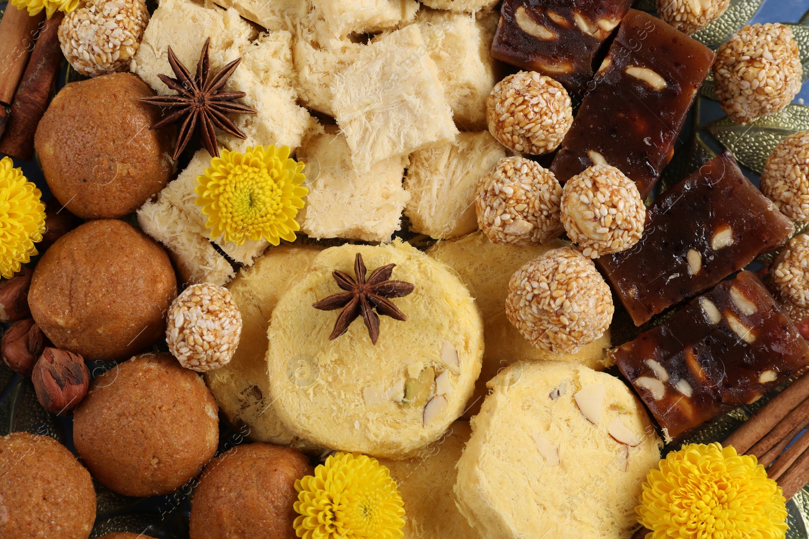 Photo of Diwali celebration. Tasty Indian sweets, spices and nuts on table, top view