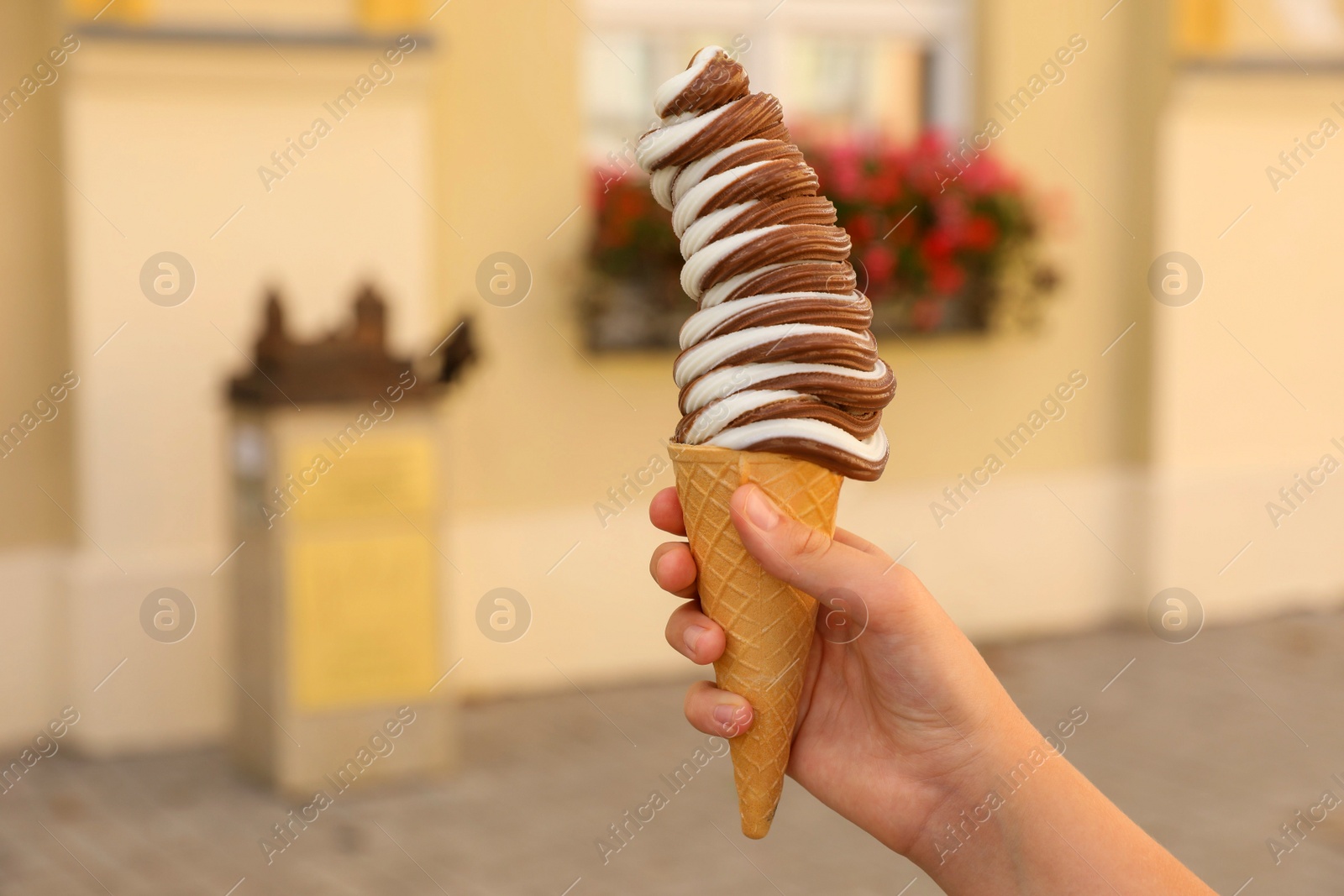 Photo of Woman holding delicious ice cream outdoors, closeup. Space for text