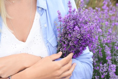 Woman with bouquet of beautiful lavender flowers outdoors, closeup