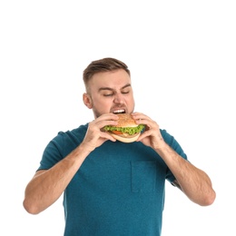 Photo of Young man eating tasty burger on white background