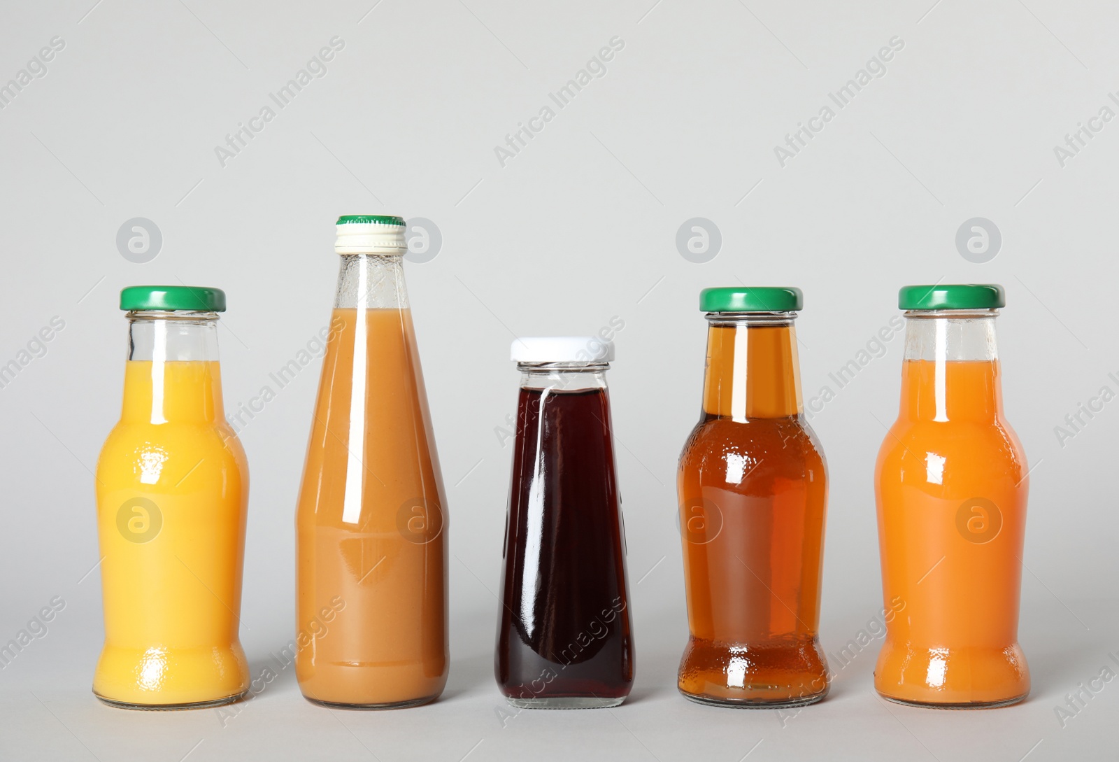 Photo of Bottles with different drinks on color background