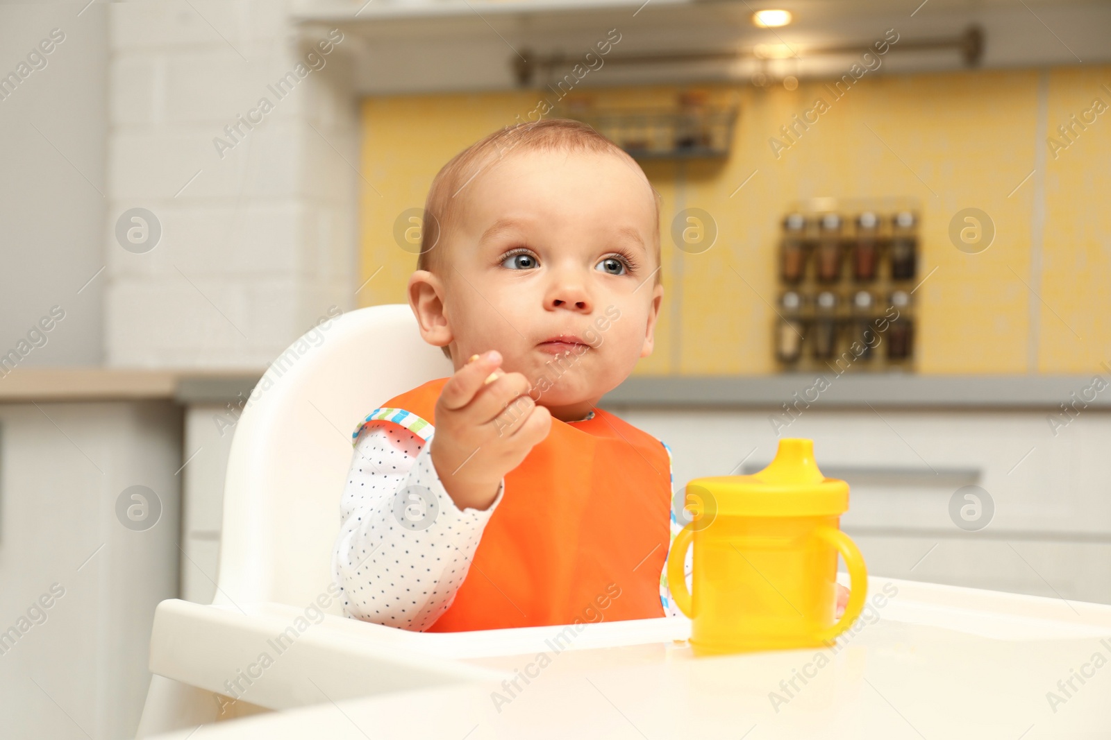 Photo of Cute little baby eating cookie at home