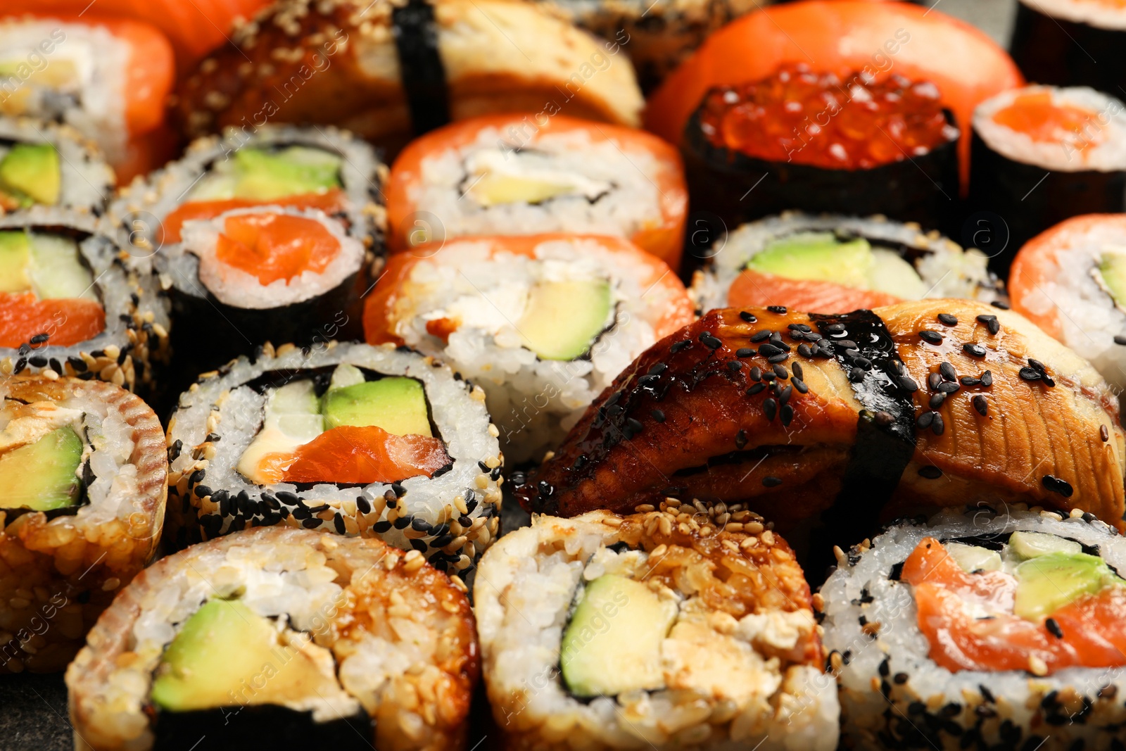 Photo of Different tasty sushi rolls as background, closeup