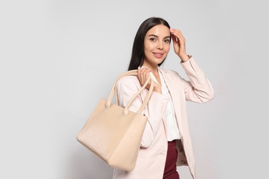 Young woman with stylish bag on white background