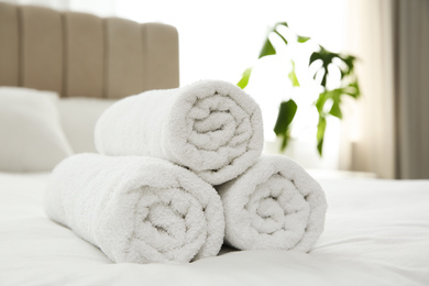 Clean white towels on bed at home