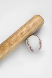 Photo of Wooden baseball bat and ball on white background, top view. Sports equipment