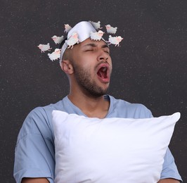 Insomnia. Tired man with pillow yawning. Illustrations of sheep running around his head against dark background