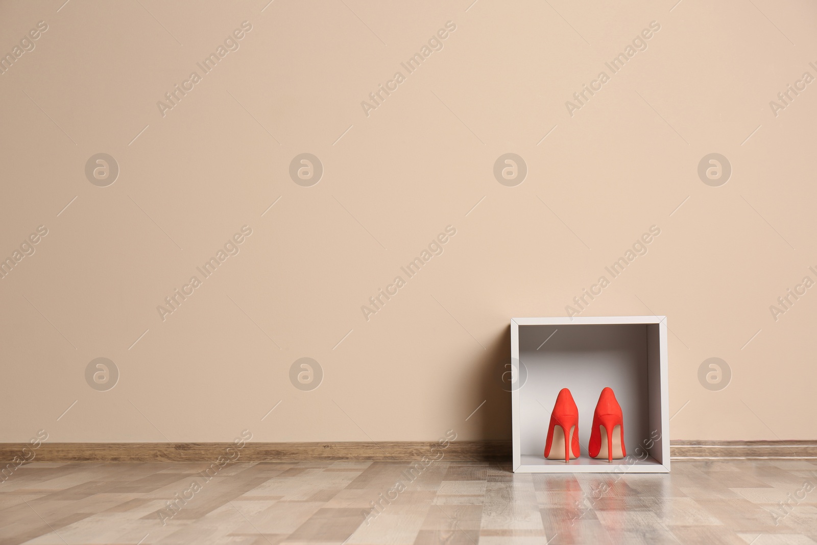 Photo of Modern cabinet with high heeled shoes near color wall, space for text