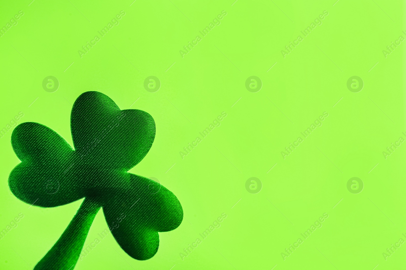 Photo of Decorative clover leaf on light green background, space for text. Saint Patrick's Day celebration