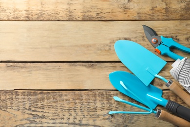 Photo of Flat lay composition with professional gardening tools on wooden background