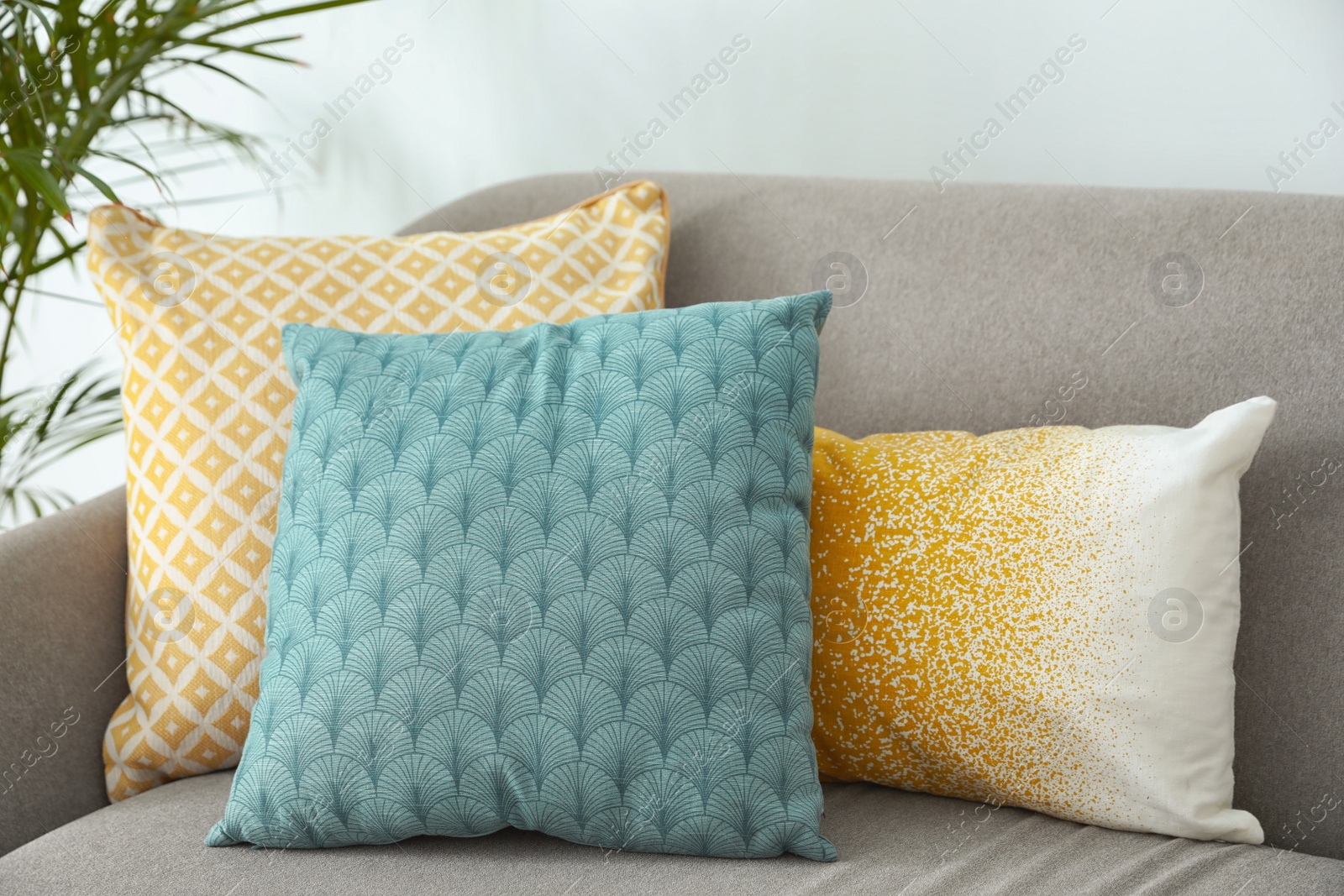 Photo of Different soft pillows on sofa in living room