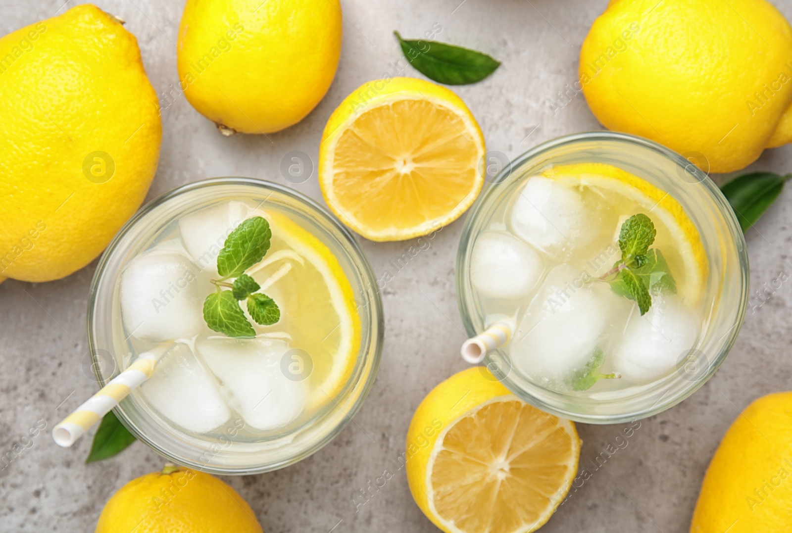 Photo of Cool freshly made lemonade and fruits on grey table, flat lay