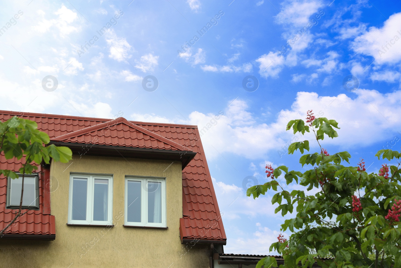 Photo of Beautiful house with red roof against blue sky