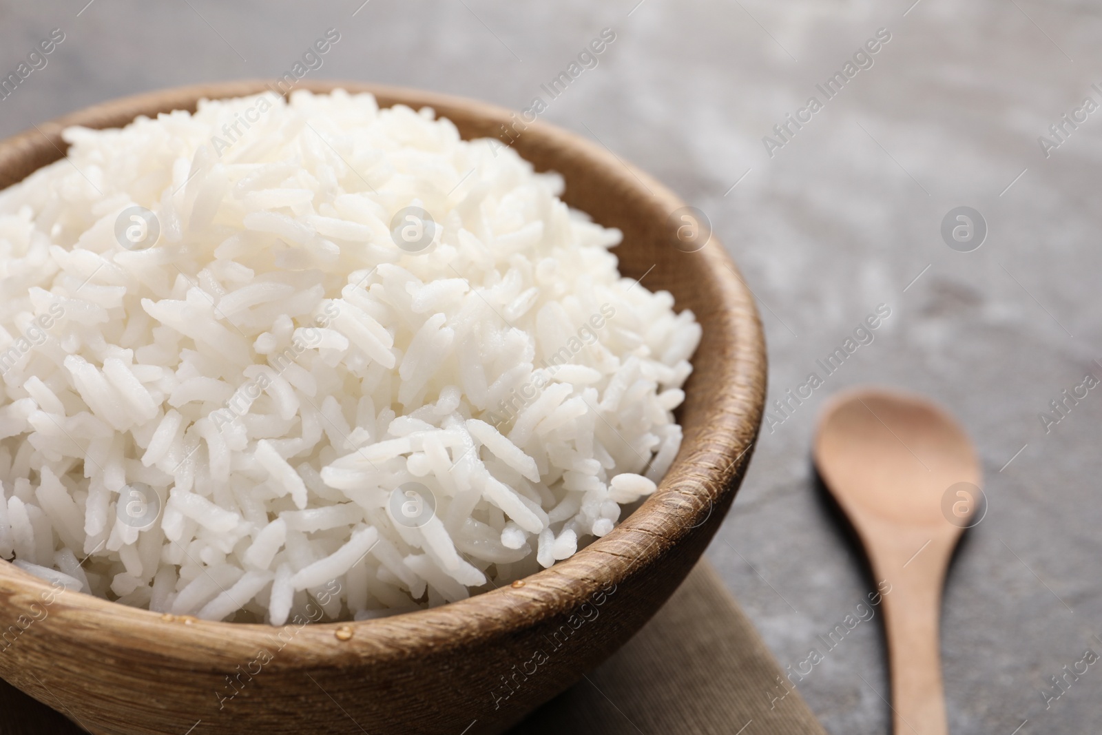 Photo of Bowl of tasty cooked rice served on table, closeup. Space for text