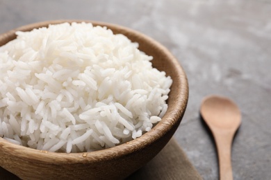 Bowl of tasty cooked rice served on table, closeup. Space for text