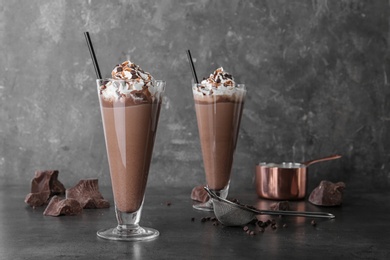 Photo of Glasses with chocolate milk shakes on grey table