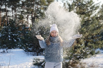 Photo of Woman playing with snow in winter forest