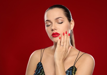 Photo of Portrait of beautiful young woman with bright manicure on color background. Nail polish trends