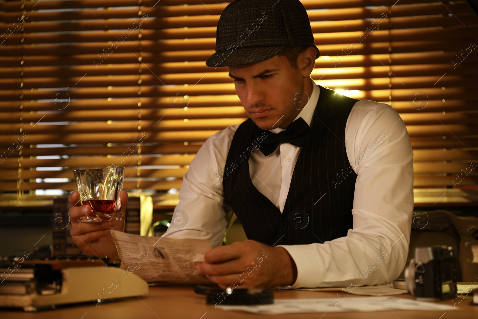 Photo of Old fashioned detective with drink working at table in office