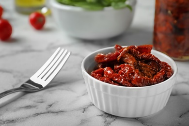 Photo of Bowl with sun dried tomatoes on marble table