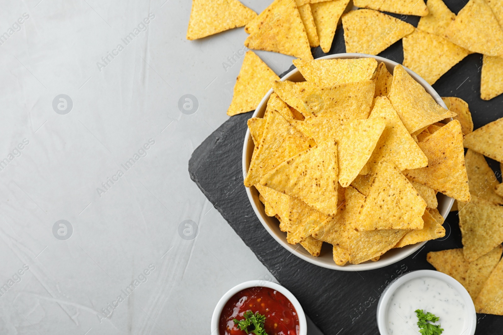 Photo of Flat lay composition with tasty Mexican nachos chips on grey table, space for text