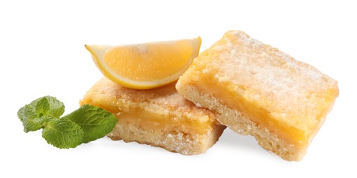 Photo of Tasty lemon bars with powdered sugar, fruit and mint isolated on white