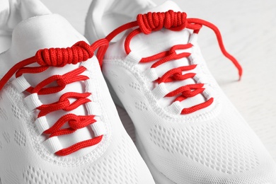 Photo of Pair of stylish shoes with red laces on white background, closeup