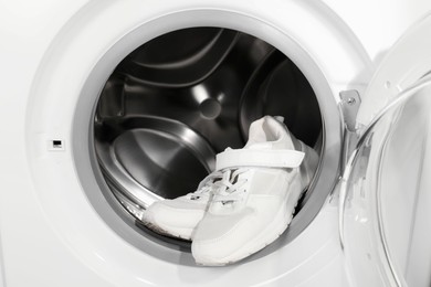 Stylish clean sneakers inside modern washing machine