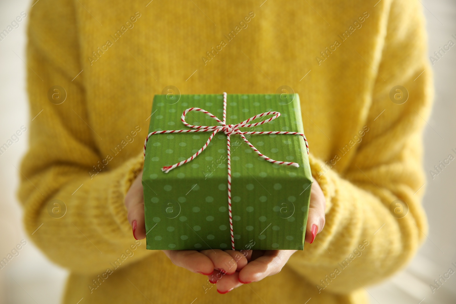 Photo of Woman holding green Christmas gift box, closeup