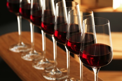 Photo of Glasses of red wine in cellar, closeup. Expensive drink