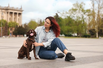 Woman with her cute German Shorthaired Pointer dog outdoors