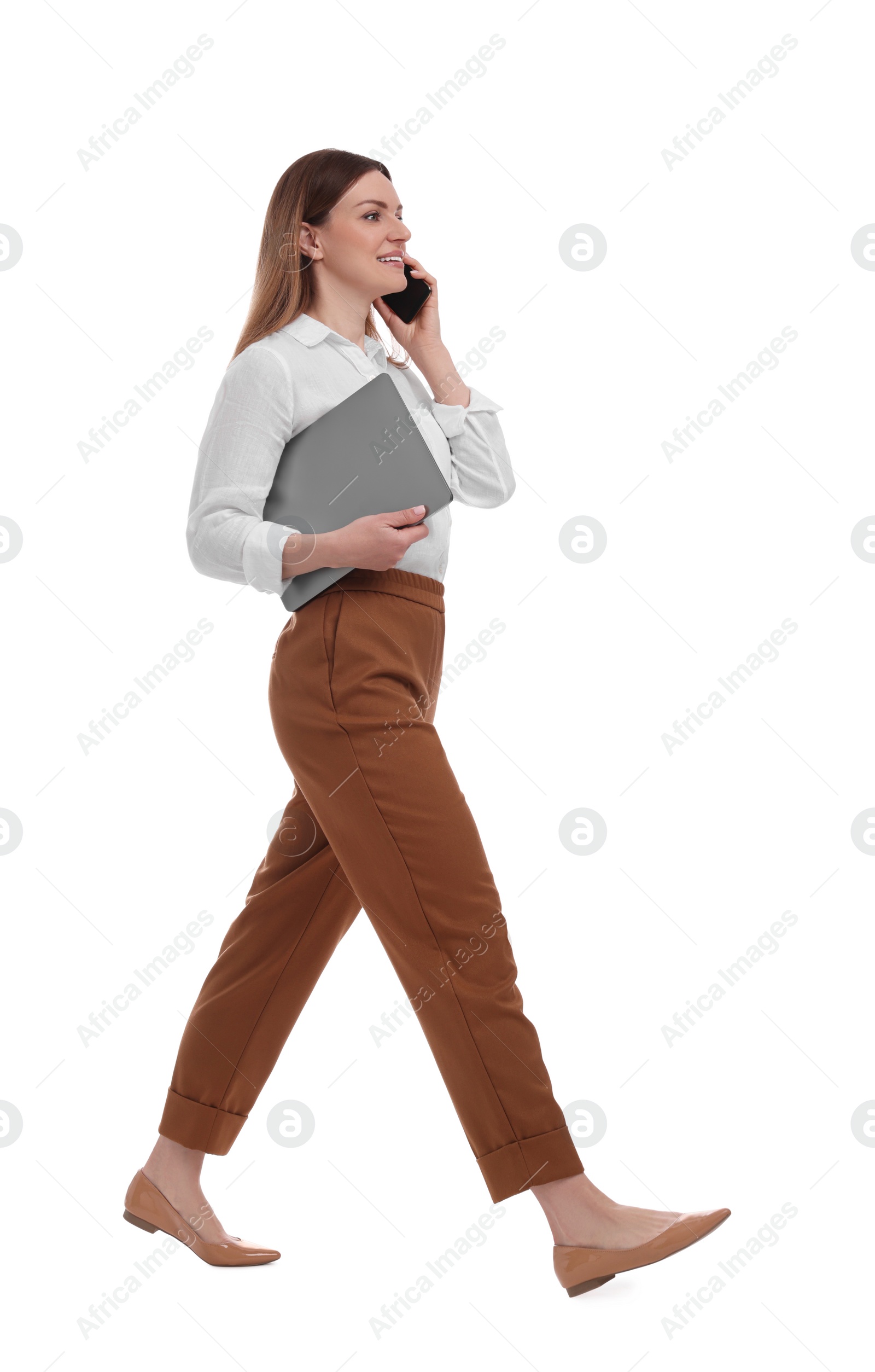 Photo of Beautiful businesswoman with laptop talking on phone against white background