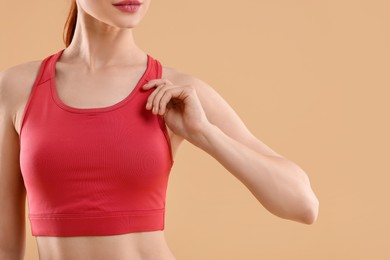 Photo of Young woman in sportswear on beige background, closeup. Space for text