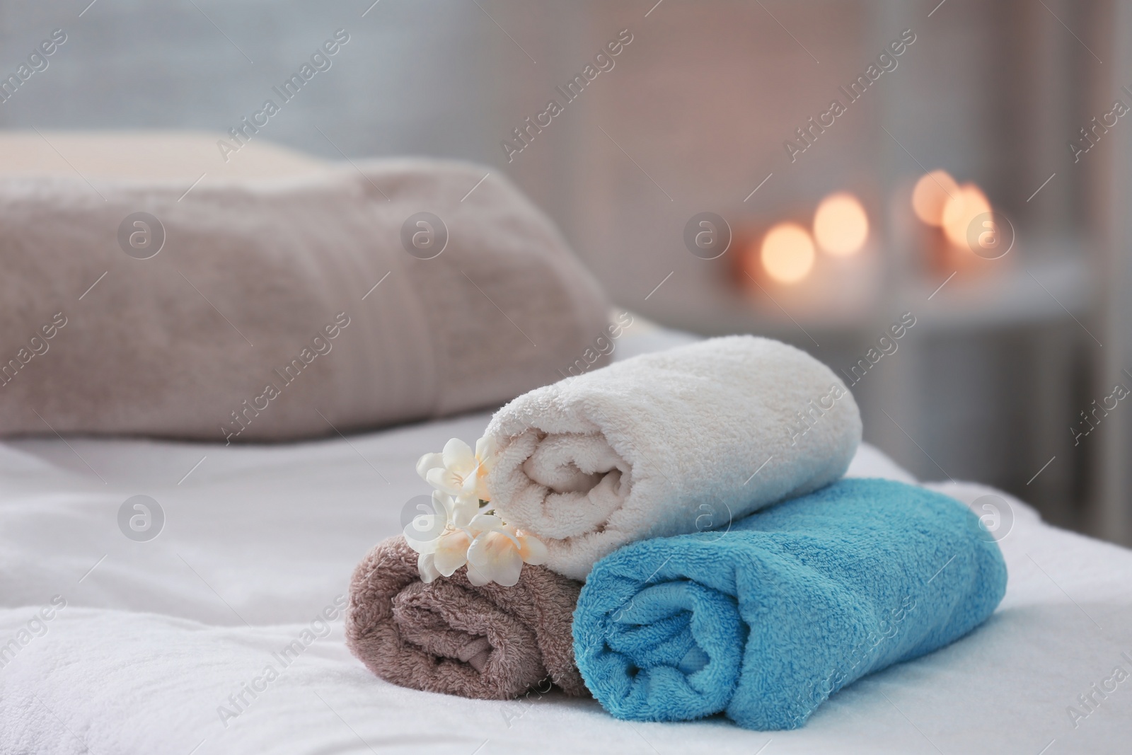 Photo of Towels and flowers on massage table in spa salon