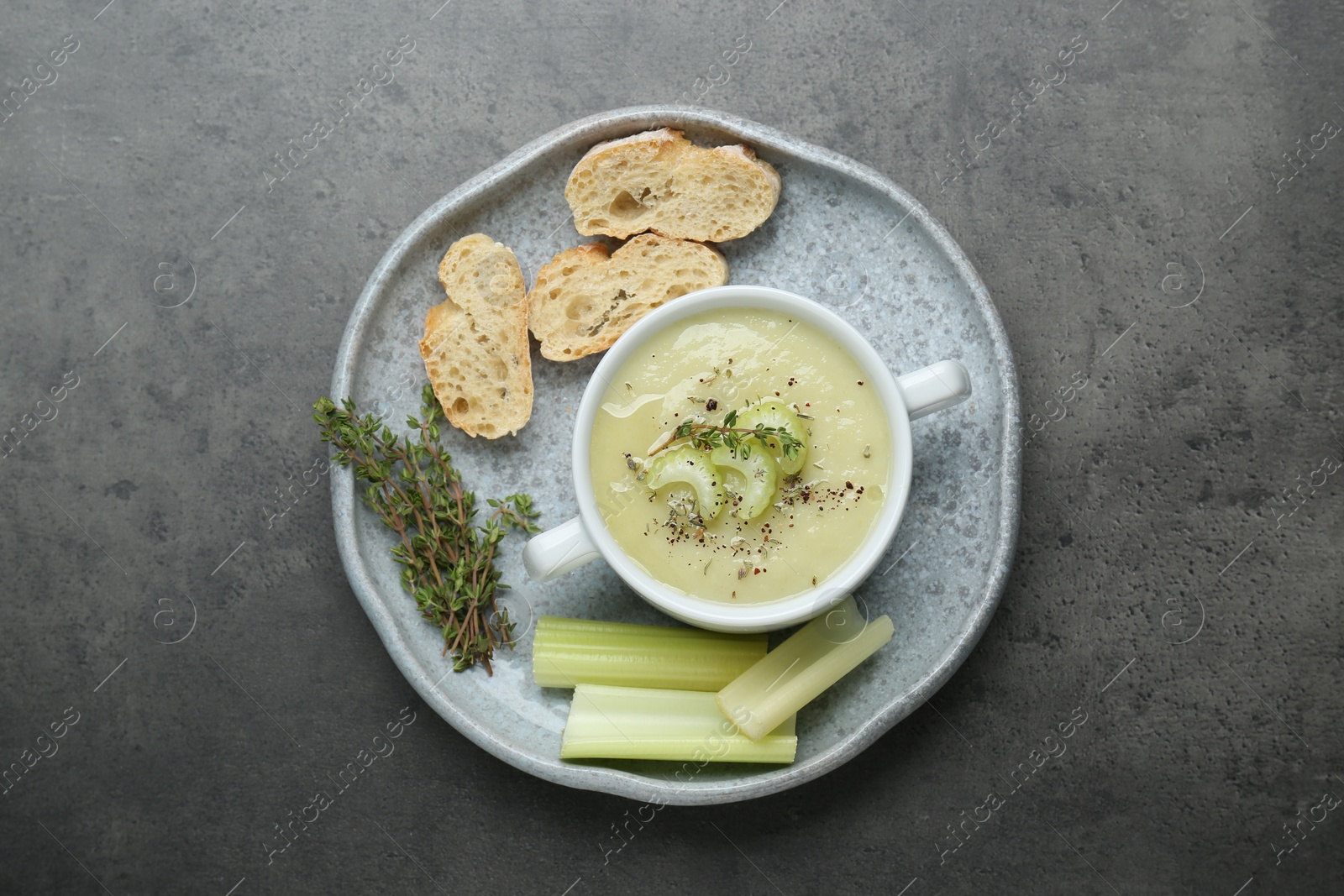 Photo of Delicious celery soup on gray table, top view