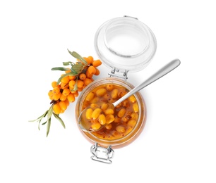 Delicious sea buckthorn jam in jar, spoon and fresh berries on white background, top view