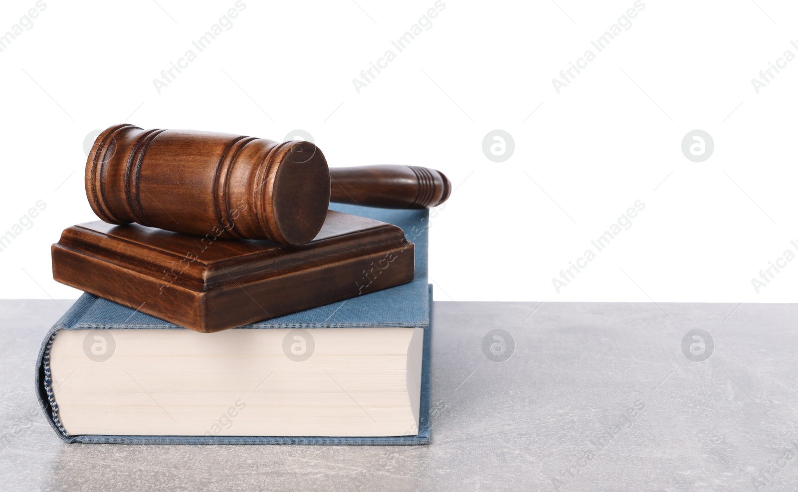 Photo of Wooden gavel, sound block and book on light table against white background. Space for text