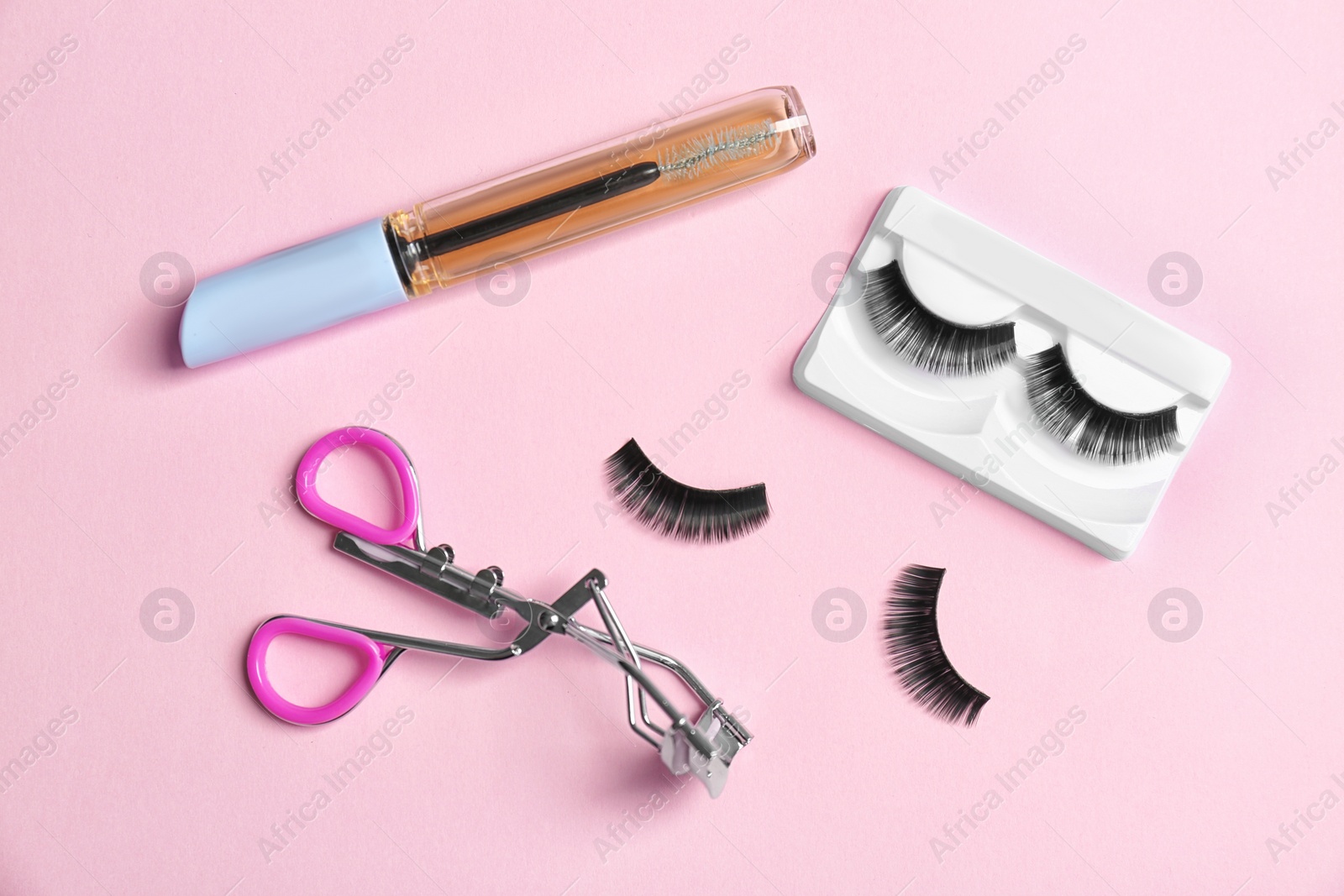 Photo of Flat lay composition with false eyelashes, oil and curler on color background