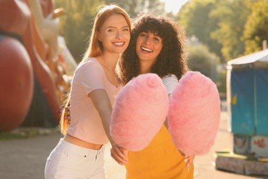 Happy friends with cotton candies outdoors on sunny day