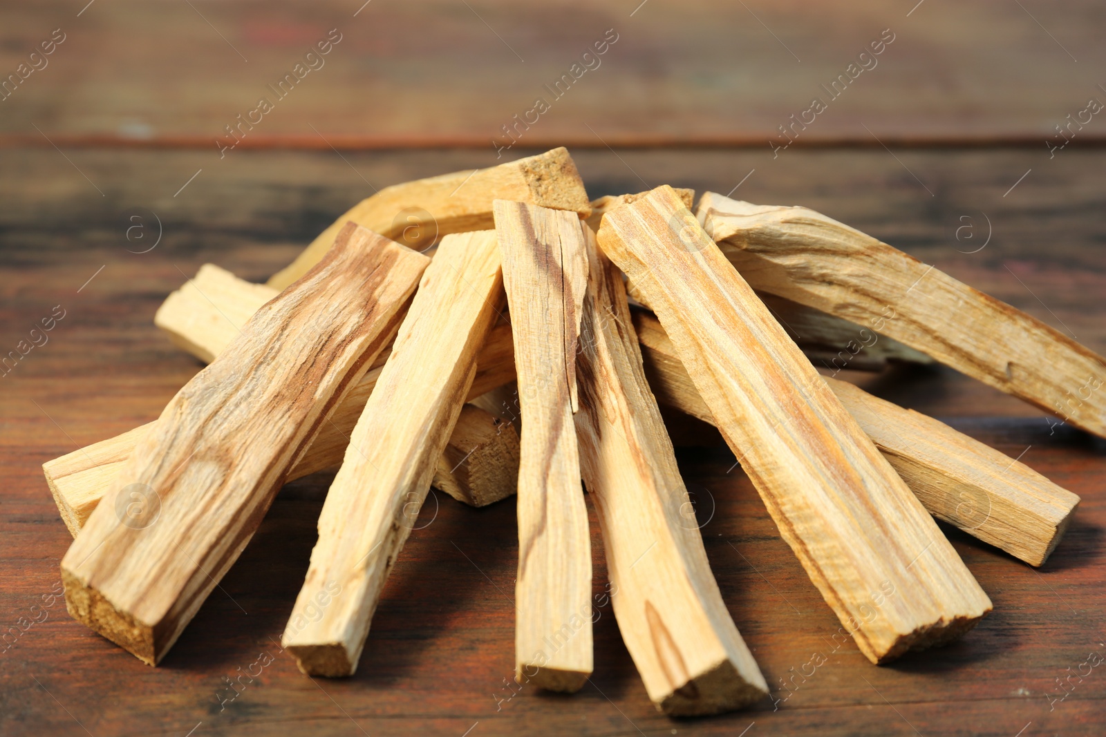 Photo of Many palo santo sticks on wooden table, closeup